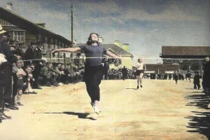 В начале 1950-х годов легкая атлетика в Охе была чрезвычайно популярна. Состязания неизменно проходили при большом количестве болельщиков. В этот раз они наблюдают за женским забегом на 100 метров. Это одна из первых цветных фотографий в истории сахалинского спорта. 

